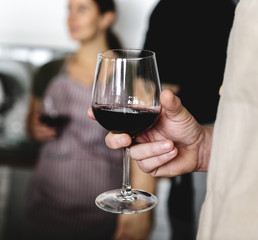 Closeup of man holding red wine glass
