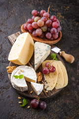 Piece of camembert cheese with grapes and nuts.