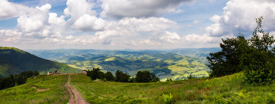panorama of beautiful landscape in mountains. gorgeous view from Borzhava mountain ridge. road down the grassy hill to tourist base. wonderful summer weather with cloudy sky