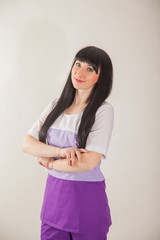 Young girl in uniform of medical worker. Doctor of the clinic in lilac uniform