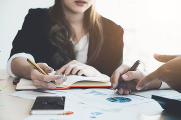Image of business partners discussing documents and ideas at meeting with financial document and calculator on workplace