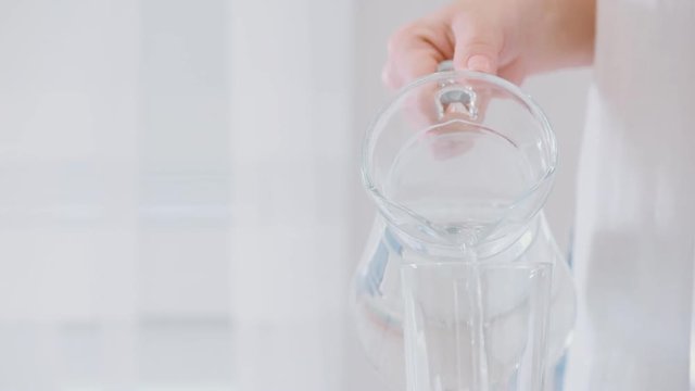 Water pouring from a pitcher into a glass.