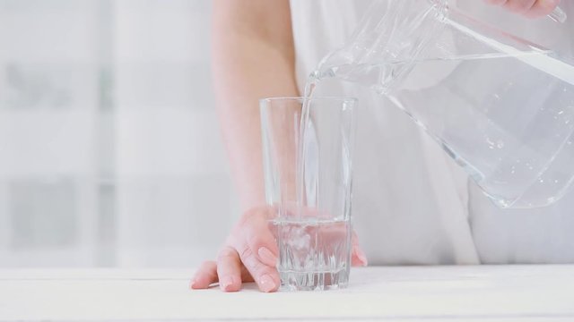 Water pouring from a pitcher into a glass.