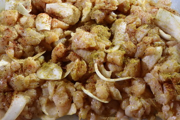 close-up of chopped chicken with colorful Indian seasoning on top