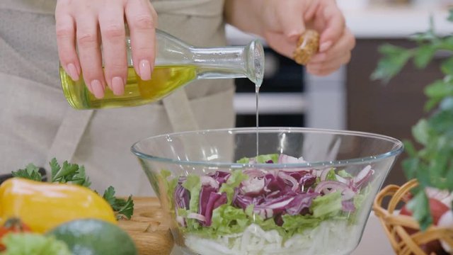 Cinemagraph - Pouring olive oil on freshly made salad.  Motion Photo.