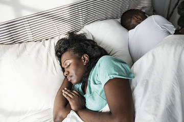 Fototapeta na wymiar Black couple sleeping on bed