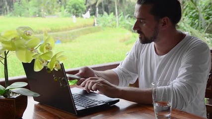 Tourism blogger posting travel tips, typing on laptop