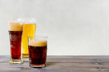 Three glasses of various beers on the wooden table