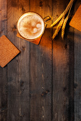 Obraz na płótnie Canvas Wooden background with beer mug and wheat ears