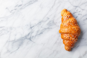 Croissants on marble table. French traditional pastry. Top view. Copy space.