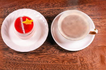 Cup of black coffee and Cake with jelly cream on wooden background with copy space .