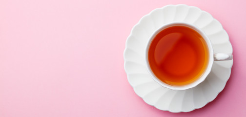 Cup of tea on pink background. Top view. Copy space