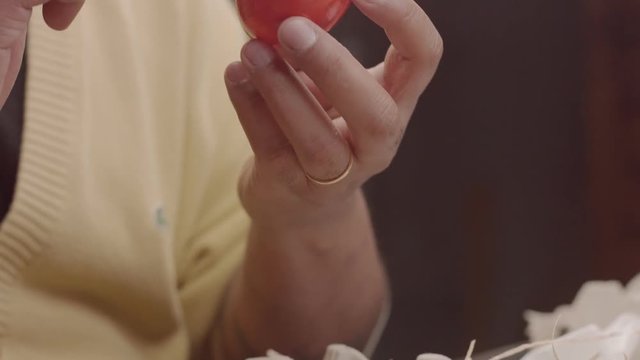 man's hand painting egg in redy