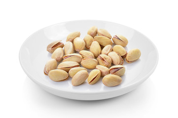 pistachios in plate on white background