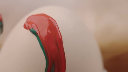 closeup of easter egg shell and brush with different color painting n it