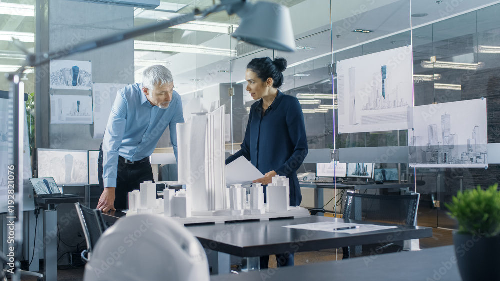 Aufkleber in the architectural bureau two engineers work on a model of a city district. urban planners work on