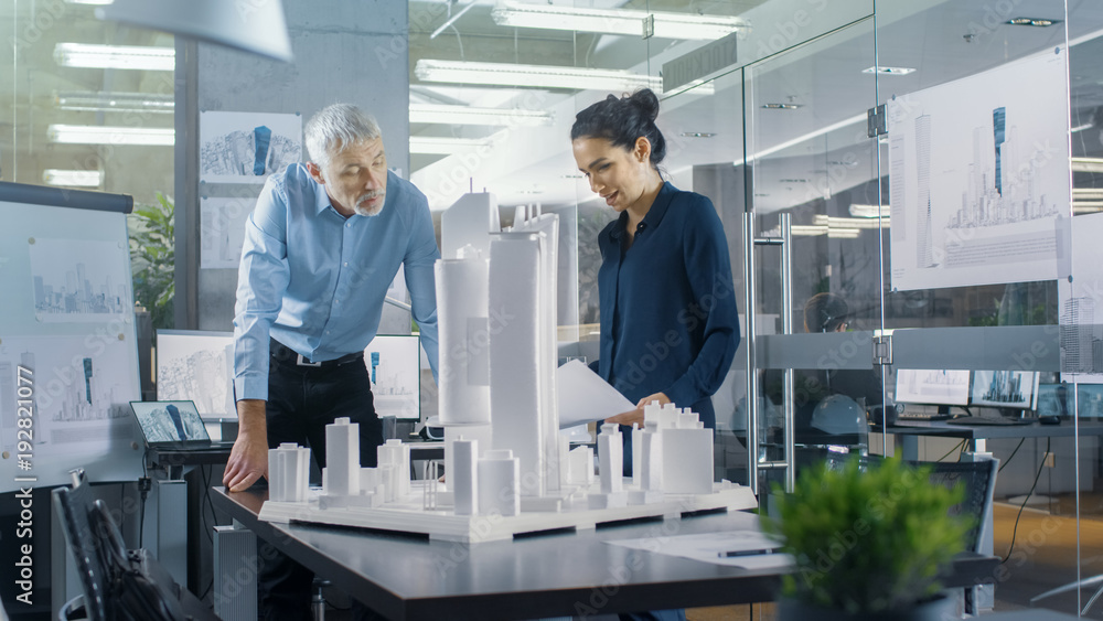 Aufkleber in the architectural bureau two engineers work on a model of a city district. urban planners work on