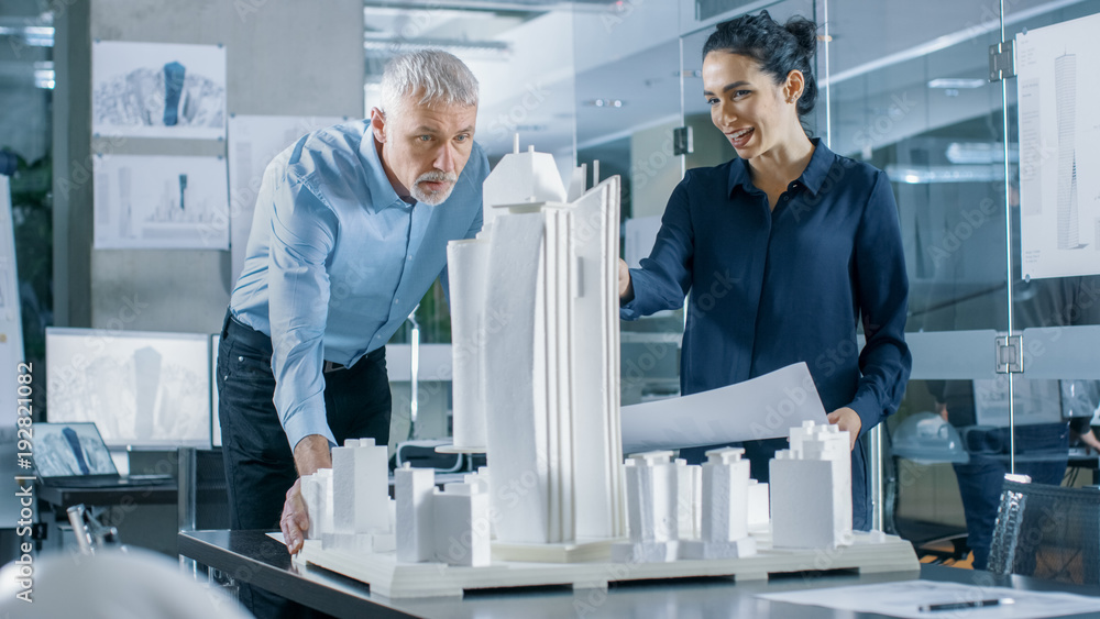 Aufkleber in the architectural bureau two professional engineers work on a model of a city district. urban pla