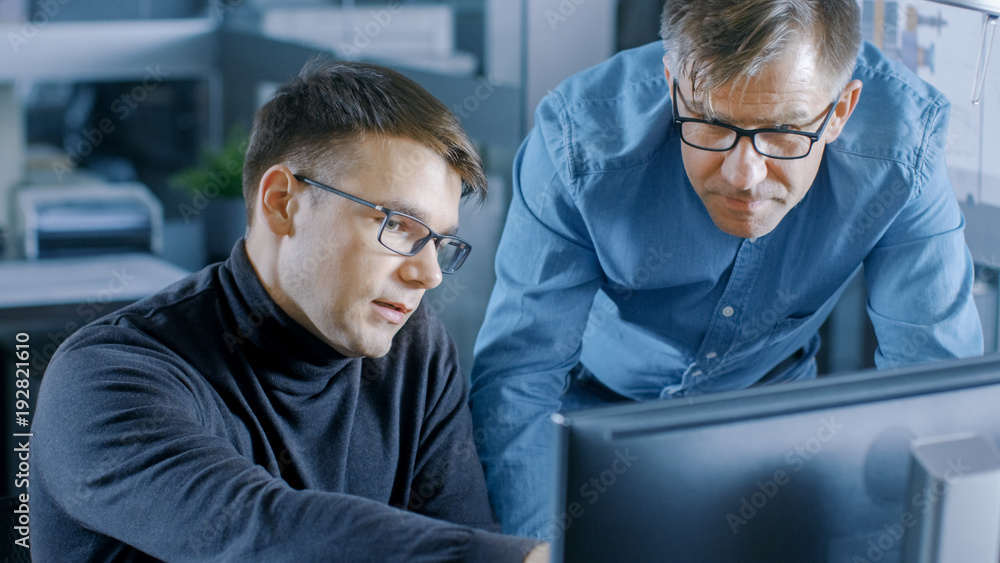 Aufkleber experienced senior engineer consults young designer about project, they have discussion and work on 