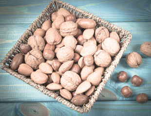 Different types of nuts in a shell on a wooden background.