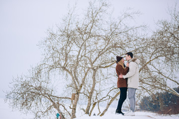 Loving couple in a pine forest in winter