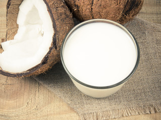 Coconut with coconut milk on wooden background.