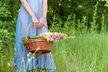 a basket of flowers in the hands of a young girl