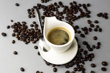 Obraz na płótnie Canvas Filiżanka espresso i rozsypane ziarna kawy