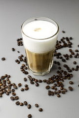 szklanka latte i rozsypane ziarna kawy