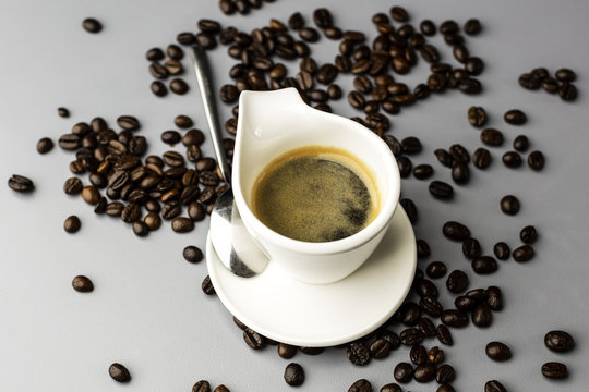 Filiżanka espresso i rozsypane ziarna kawy