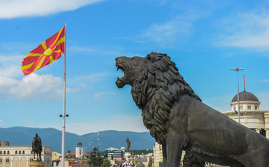 Lion statue at Skopje town square, macedonian flag