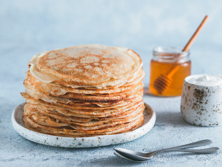 Stack of traditional russian pancakes blini on gray background with copy space. Homemade russian...