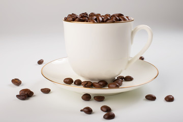 White cup with coffee beans on white background