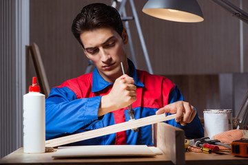 Young man gluing wood pieces together in DIY concept