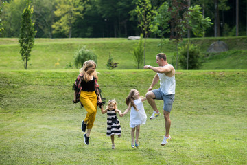 Children and parents jump on green grass