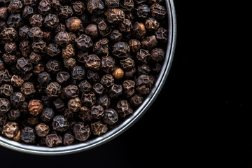Black pepper seeds in pot with copy space