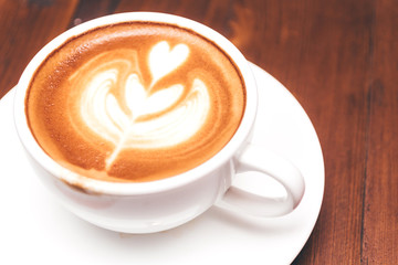 Coffee latte art on wooden table in coffee shop