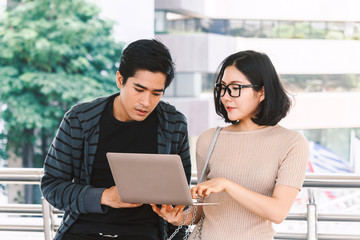 Two teenager students doing homework with laptop at university