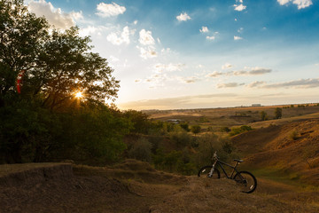 Obraz premium mountain bike in the background of a beautiful sunset, on the edge of the forest