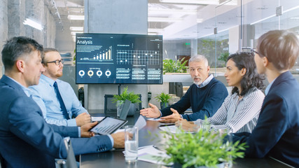 Board of Directors Has Annual Meeting, Diverse Group of Business People in the Modern Conference Room Discuss Statistics and Work Results. In the Background Projector Showing Company Growth.