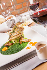 Fried zander, millet with green vegetables, fried boletus with thyme on a green leaf with some egg...