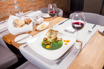 Fried zander, millet with green vegetables, fried boletus with thyme on a green leaf with some egg...