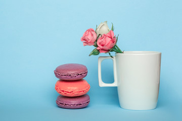 tea cup with rose flower and violet macarons