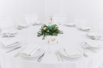 a wedding table with cutlery, candles and flowers.