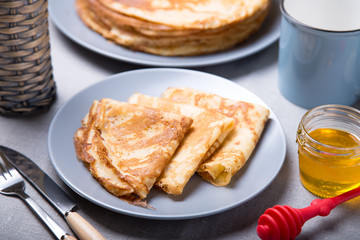 Traditional Russian pancakes with honey. Shrovetide. Maslenitsa week. Selective focus, close-up.