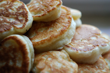 Thick russian pancakes piled on neutral background.