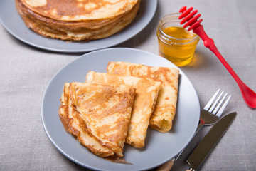 Traditional Russian pancakes with honey. Shrovetide. Maslenitsa week. Selective focus, close-up.