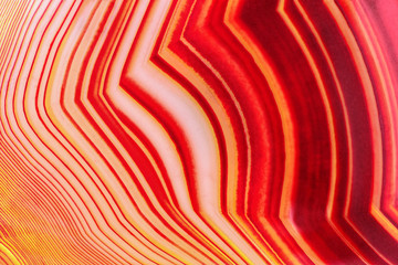 Amazing Banded Red Agate Crystal cross section as a background. Natural light translucent agate crystal surface,  Colorful abstract expressive structure slice mineral stone macro closeup