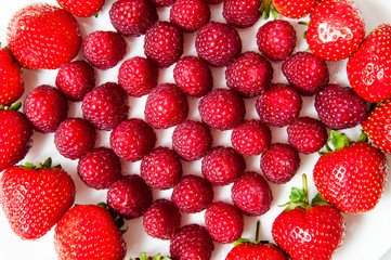 fresh raspberries and strawberries on a white plate