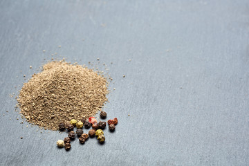 Mix of grind black pepper and black, white, red and yellow peppercorn. Selective focus.